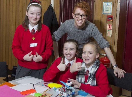 Children with their student teacher giving technology the “thumbs up”