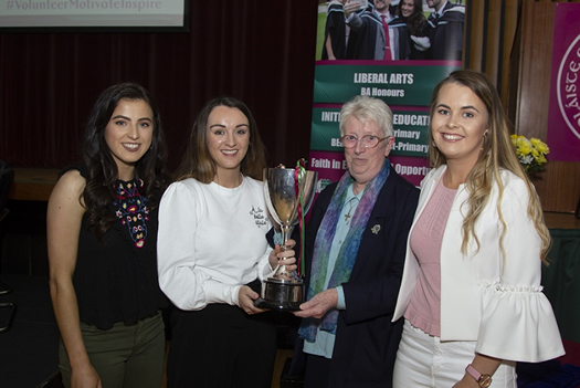 Sr Lucina Montague (member of the College Board of Governors) and students with the Fr Meachair Cup won in February 2018 by the Camogie team.