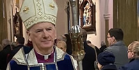 Archbishop Noel Treanor in his traditional dress of Mitre (head dress), Alb (inner garment) and Chasuble (outer cape) and walking down the central aisle of St Peter's Cathedral in Belfast. 